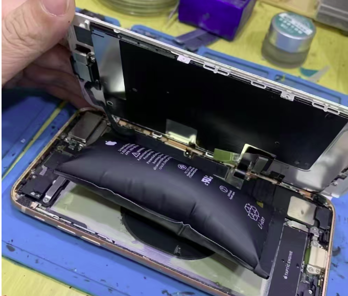 Swollen lithium battery inside smartphone damaged by extreme heat during summer shipping